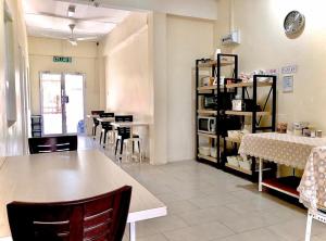 a dining room with tables and chairs and a clock at Ozzy Lodge Semporna in Semporna