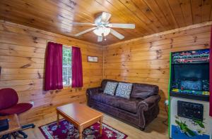 a living room with a couch and a ceiling fan at Ladybug Resort Romantic Cabin With Mountain Views, Game Room, Close to Dollywood in Sevierville
