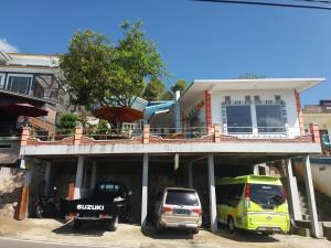 Bintang Bungalow Tour & Travel في كيليموتو: منزل فيه سيارات تقف امامه