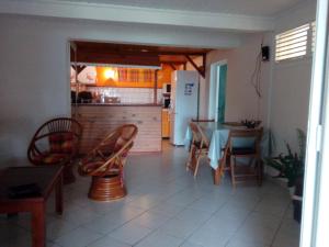 eine Küche und ein Esszimmer mit einem Tisch und Stühlen in der Unterkunft La Villa Jasmin in Les Anses-dʼArlets