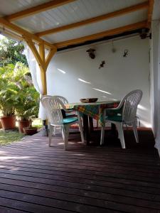 2 Stühle und ein Tisch auf der Terrasse in der Unterkunft La Villa Jasmin in Les Anses-dʼArlets