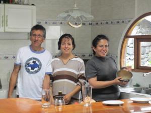 un grupo de tres personas de pie en una cocina en Hospedaje Higueron, en Baños