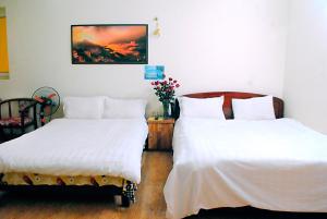 サパにあるMinh Anh Guesthouseのベッドルーム1室(隣り合わせのベッド2台付)