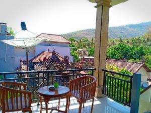 a patio with a table and chairs on a balcony at Tira Amed Homestay in Amed