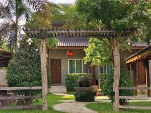 a house with a wooden pergola in front of it at Home Inn Pai Garden in Pai
