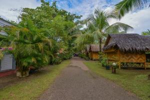 um caminho através de uma aldeia com palmeiras e casas em Bananas Resort & Restaurant em Tha Lane Bay