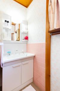 a bathroom with a sink and a pink tiled wall at Family house (private house) in Osaka