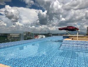 - une grande piscine avec un parasol rouge au-dessus d'un bâtiment dans l'établissement Fantastic condo in boutique La Grande resort, à Ángeles