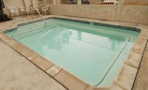 a swimming pool with blue water in a building at Regency Inn in Moreno Valley