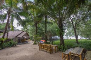 a park with benches and palm trees and a building at Bananas Resort & Restaurant in Tha Lane Bay