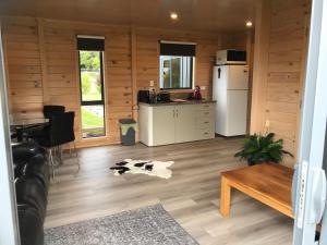 a kitchen and a living room with a cow on the floor at Aroha Anchor Apartment in Motueka