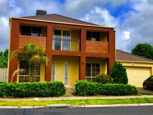 a orange house with a car parked in front of it at Golf View Charm in Craigieburn