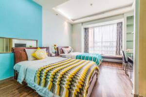 two beds in a room with blue walls and a window at Shanghai Jiarong Hotel Apartment in Shanghai