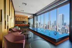 a bar with chairs and a view of a city at Osaka Excel Hotel Tokyu in Osaka