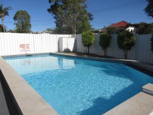 uma piscina em frente a uma cerca branca em Riviera on Ruthven em Toowoomba