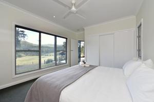 a bedroom with a large white bed and a large window at Valle Laguna in Laguna
