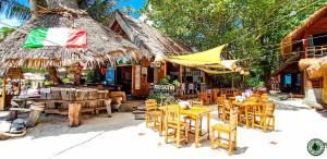 a restaurant with chairs and tables and a straw umbrella at Forra Pattaya Beach Front Bungalow in Ko Lipe