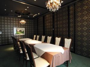 Un comedor con una mesa y sillas y una lámpara de araña. en Yugashima Golf Club & Hotel Resort, en Izu