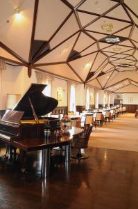 Habitación con piano, mesas y sillas en Yugashima Golf Club & Hotel Resort, en Izu