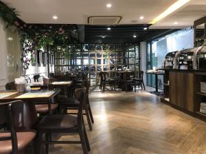 ein Speisesaal mit Tischen und Stühlen in einem Restaurant in der Unterkunft The Herriott Hotel & Suite in Đà Nẵng