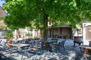 a group of tables and chairs under a tree at Tullius Die Rebmeisterei in Bad Sobernheim