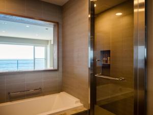 Shirahama Key Terrace Hotel Seamore في شيراهاما: حمام مع حوض استحمام ونافذة