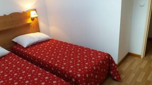 - un lit rouge dans une chambre avec une couette rouge dans l'établissement Beau T3 ensoleillé au pied des pistes, à Arvieux