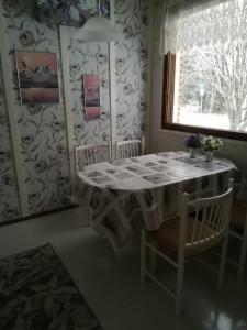 d'une salle à manger avec une table, des chaises et une fenêtre. dans l'établissement Köpsintie 4, à Pyhäjärvi