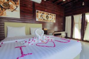 Una cama con un corazón hecho de cinta rosa en Bellewood Villa by Sadev Resort, en Gili Trawangan