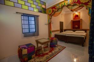 ein Zimmer mit einem Bett und einem Tisch und einem Fenster in der Unterkunft Sadar Haveli Heritage in Jodhpur