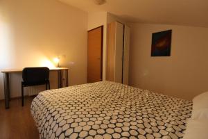 um quarto com uma cama, uma secretária e uma cadeira em villa barisic em Drnis