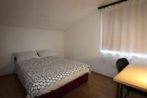um pequeno quarto com uma cama e uma janela em villa barisic em Drnis