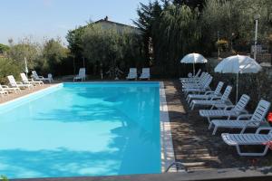 una piscina con sedie a sdraio e ombrelloni di Hotel Ismaele a Chiusi