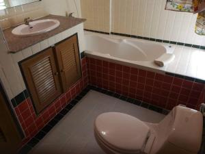 La salle de bains est pourvue de toilettes, d'un lavabo et d'une baignoire. dans l'établissement Ocean View Resort, à Ko Lanta