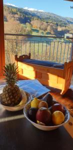 two plates of fruit on a table with a pineapple at Ferienhaus & Ferienwohnung Wiñay Wayna Gotschna Blick Klosters in Klosters Serneus