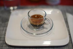 una taza de café en un plato en una mesa en La Dimora, en Catania