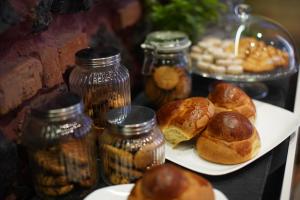 a plate of pastries and jars of food on a table at La Dimora in Catania