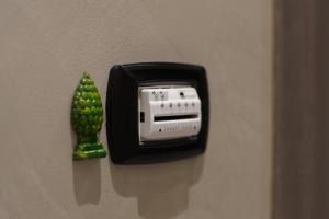 un interruptor en una pared con una planta verde. en La Dimora, en Catania