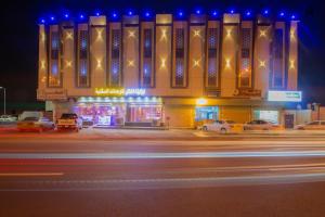 un edificio con coches aparcados delante de él por la noche en Loluat Al Matar Furnished Units, en Jazan