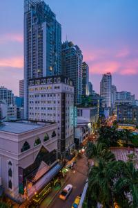 a city with tall buildings and a street at dusk at La Petite Salil Sukhumvit 11 in Bangkok