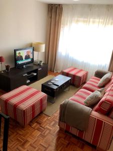 sala de estar con 2 camas y TV de pantalla plana en Lauramer Apartamento Bakio, en Bakio