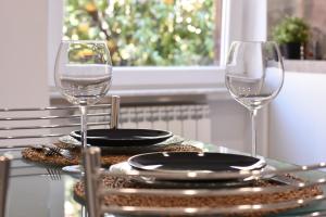 ローマにあるRampa Brancaleone Apartmentのワイングラス2杯と皿付きのテーブル