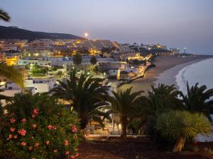 vistas a una playa con palmeras y casas en FeWo Flamingo - Morro Jable Fuerteventura, en Morro del Jable