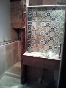 サルラ・ラ・カネダにあるLa Grange Périgourdineのタイル張りの壁、洗面台付きのバスルーム