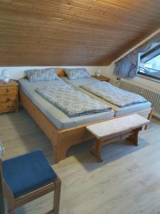 a room with two beds and a bench in a cabin at Waldblick in Schluchsee