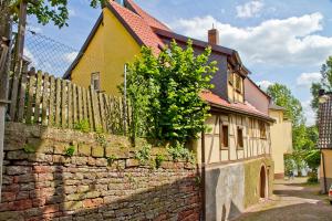une maison avec un mur en briques et une clôture dans l'établissement Ferienwohnung Fritz Walter, à Kreuzwertheim