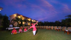 a woman standing in the grass with her arms in the air at Ranthambore Bagh Palace in Sawāi Mādhopur