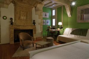 シノンにあるGîteChinon à la Maison Rougeの緑の壁のベッドルーム(ベッド1台、暖炉付)