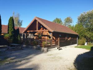 a large wooden cabin with a picnic table in front of it at Chalets les Silènes in Doucier