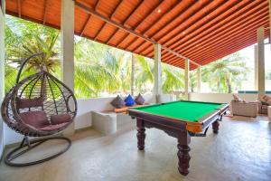 Habitación con mesa de billar y columpio en De Silva Palm Resort, en Kalpitiya